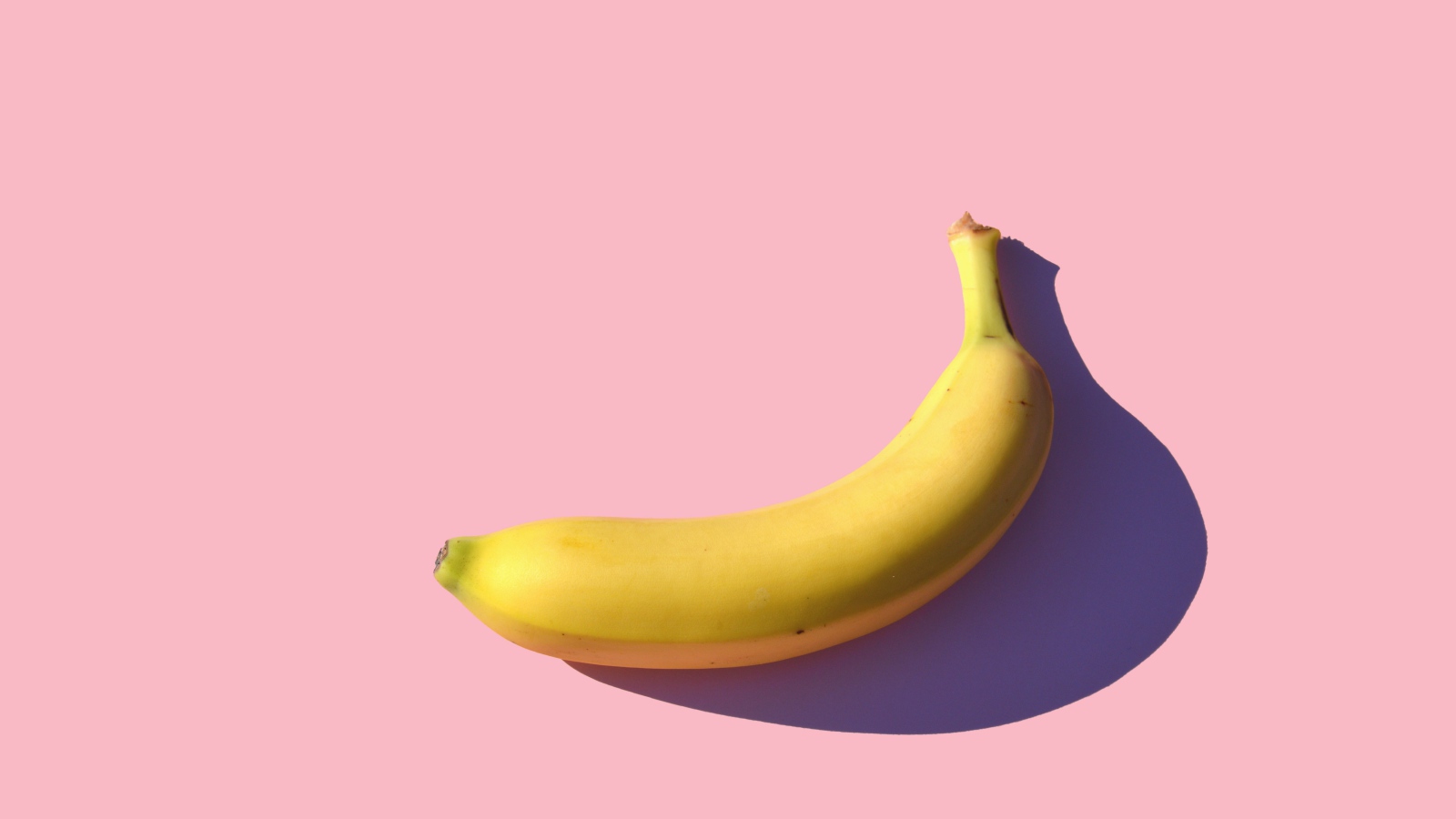 Желтый банан на розовом фоне