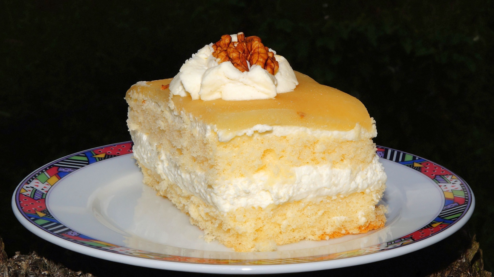Кусок торта со сливочным кремом и грецкими орехами