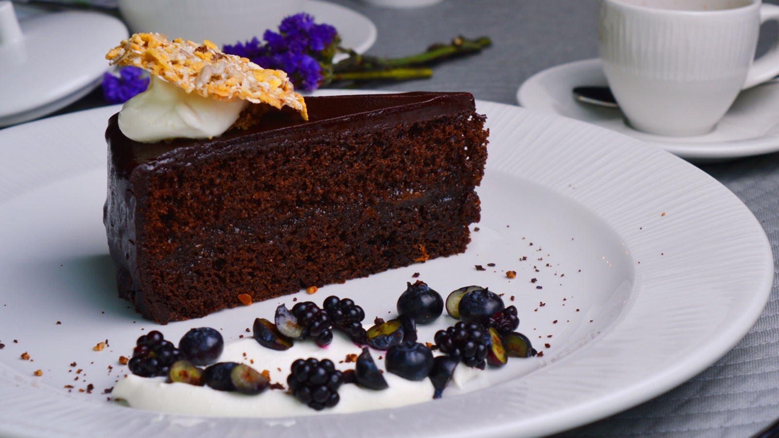 Кусок шоколадного пирога на большой белой тарелке