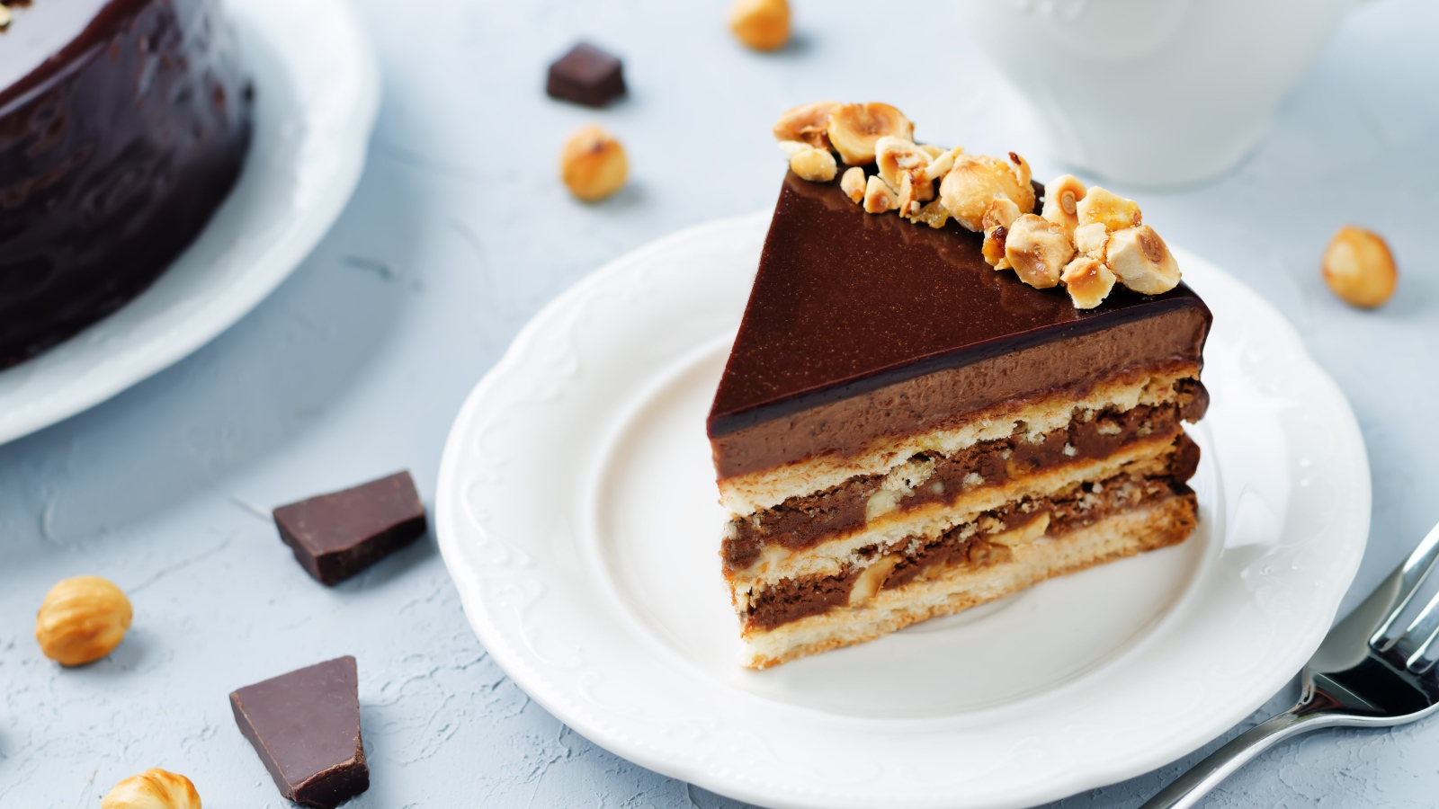 Кусок аппетитного торта с орехами на белой тарелке