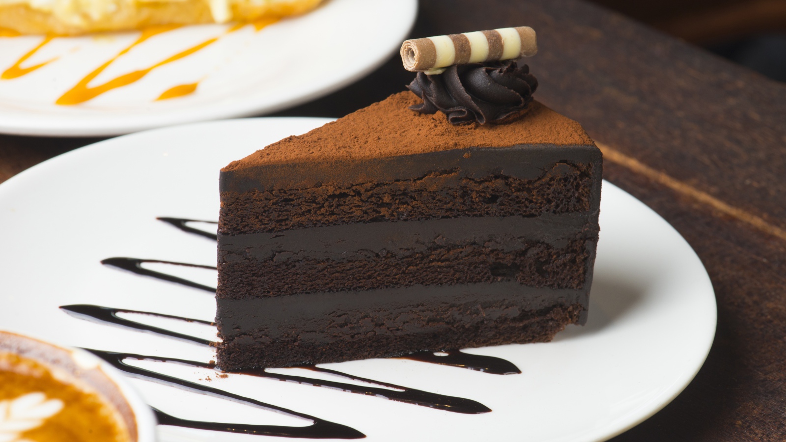 Кусок аппетитного шоколадного торта на белой тарелке