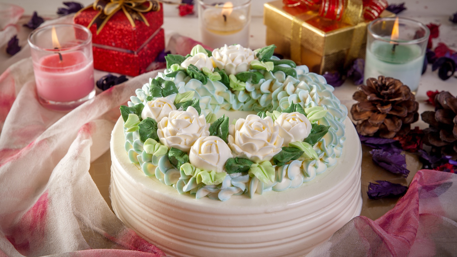 Красивый праздничный торт на столе с подарками и свечами
