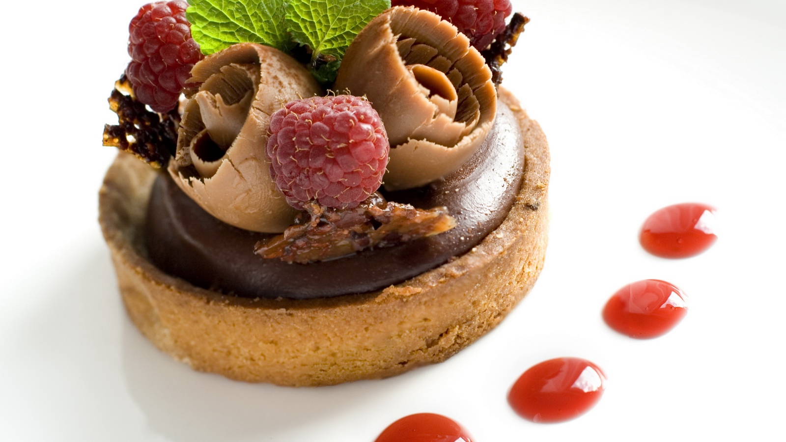 Пирожное с шоколадом и ягодами малины на белом фоне
