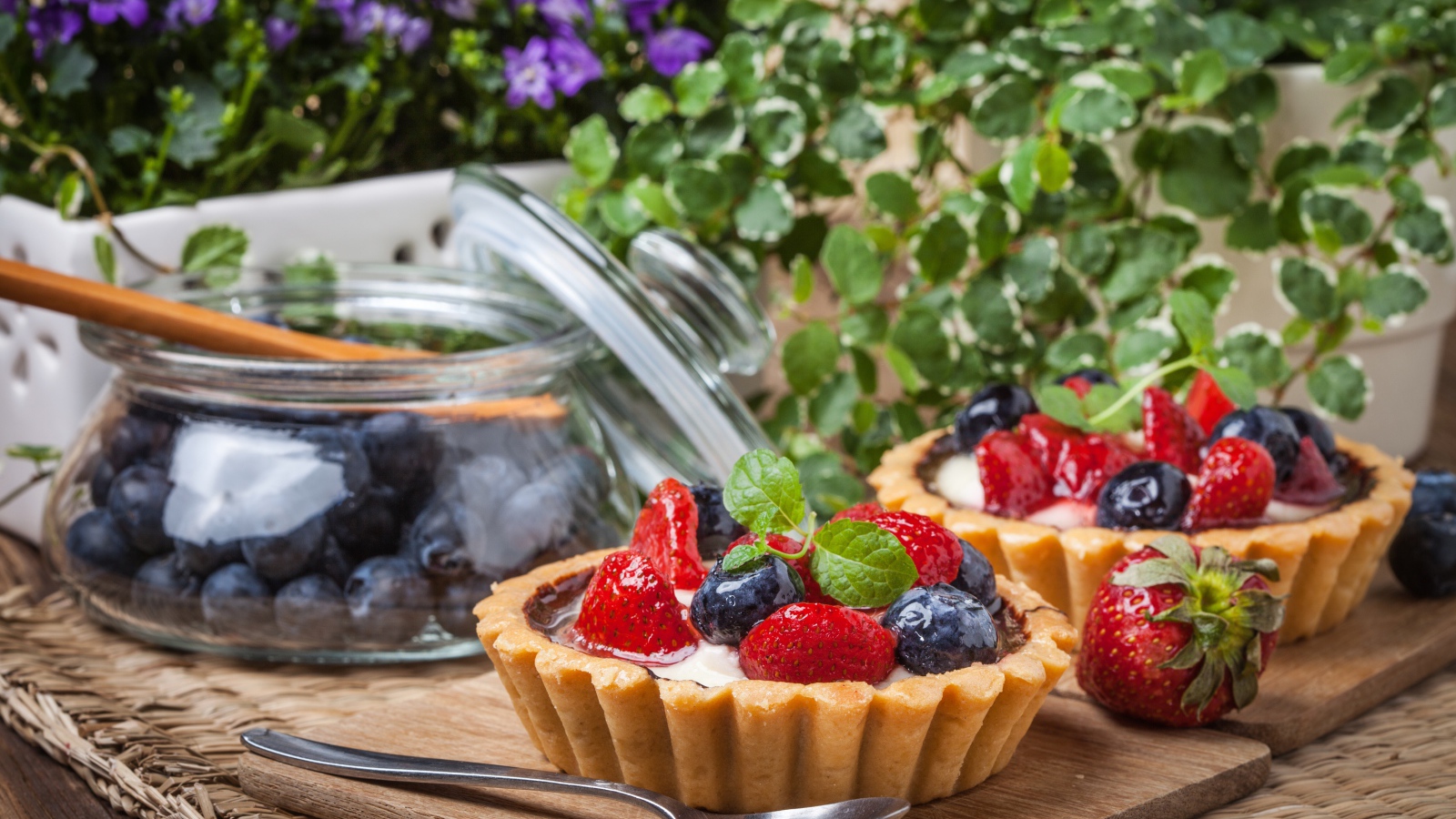 Пирожные с ягодами клубники и черники на столе