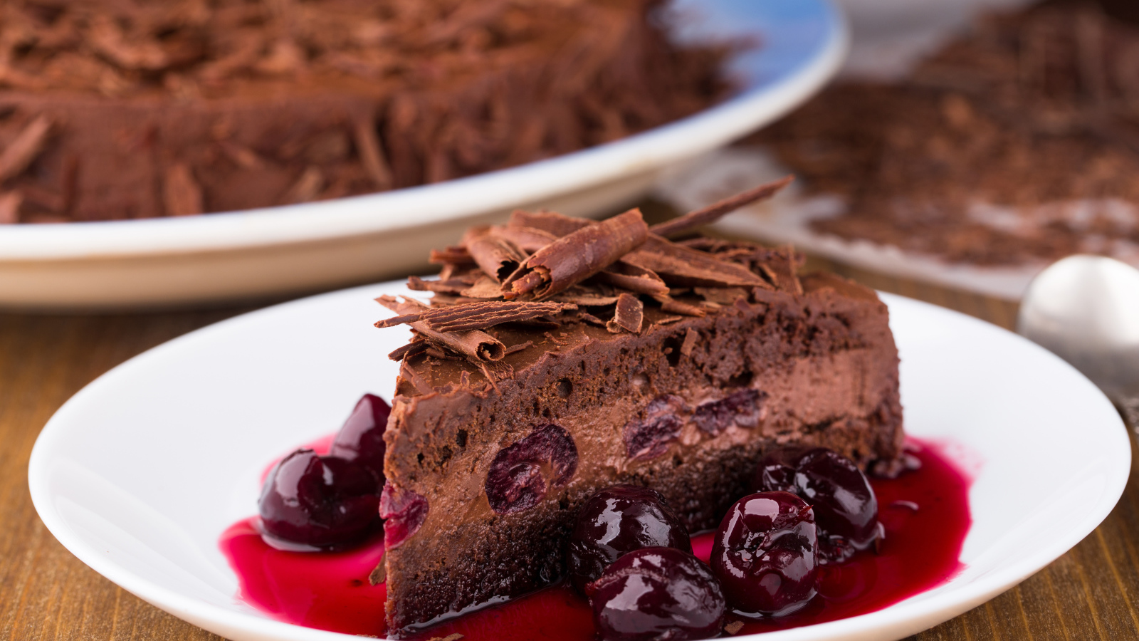 Шоколадный пирог с вишневым вареньем на белой тарелке