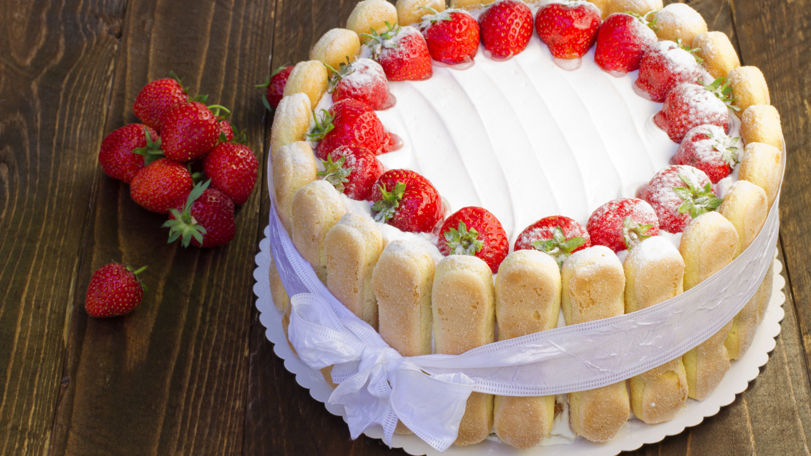 Вкусный торт с клубникой и печеньем перевязан бантом