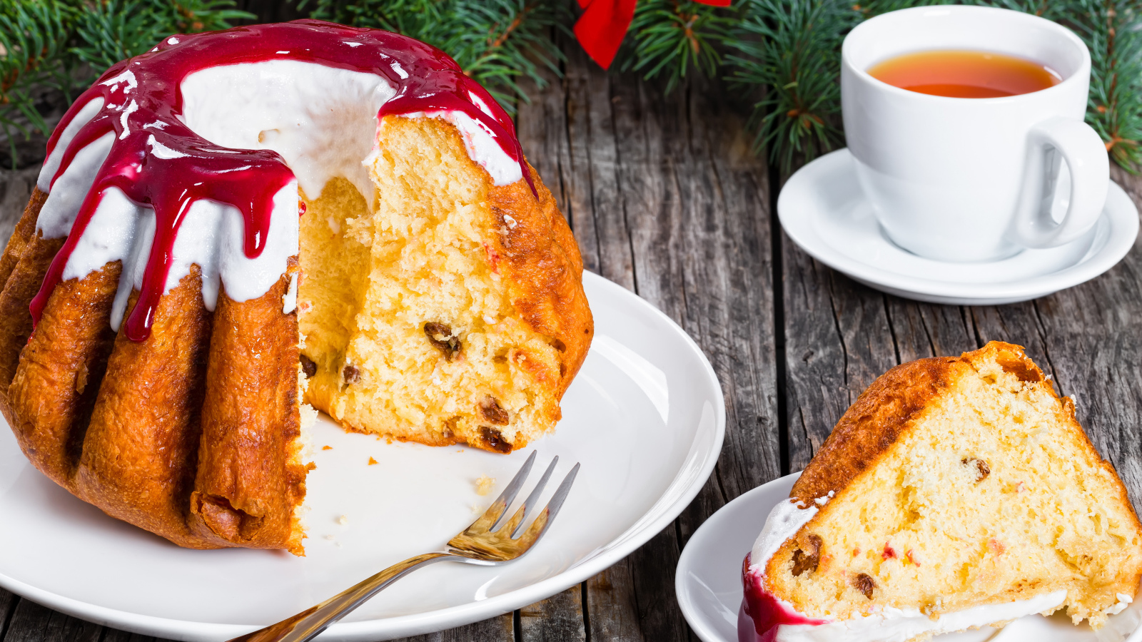 Праздничный кекс с глазурью на столе с чашкой чая