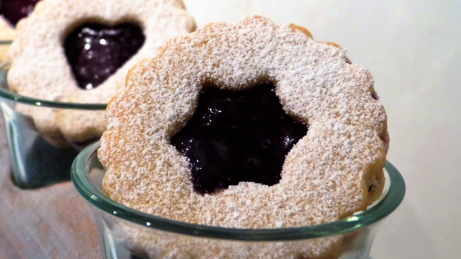 Фигурные печенья с джемом посыпанные сахарной пудрой 