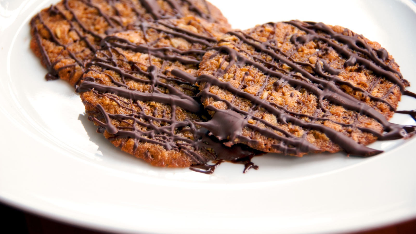 Круглое печенье с шоколадом на белой тарелке