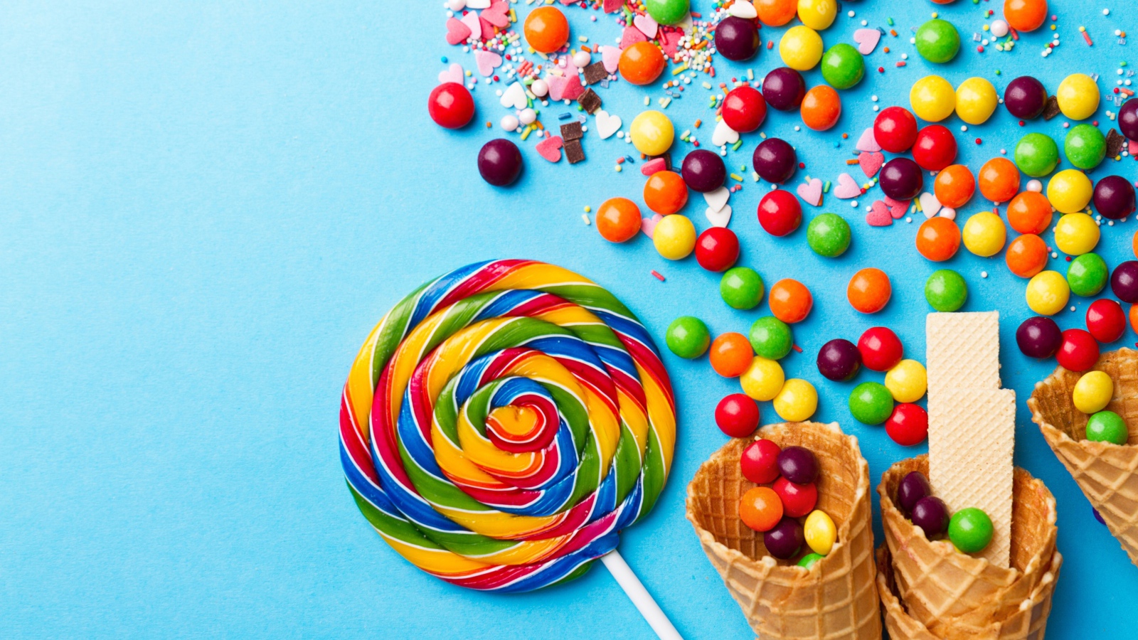 Сладкие конфеты и вафельные рожки на голубом фоне