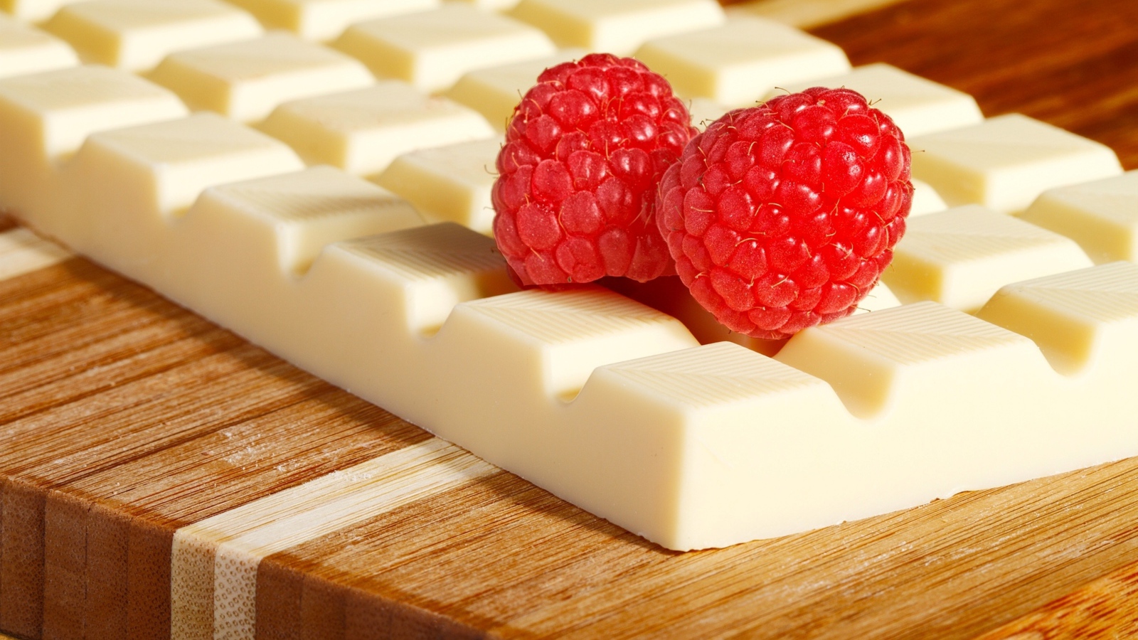 Сладкий белый шоколад с ягодами малины на столе