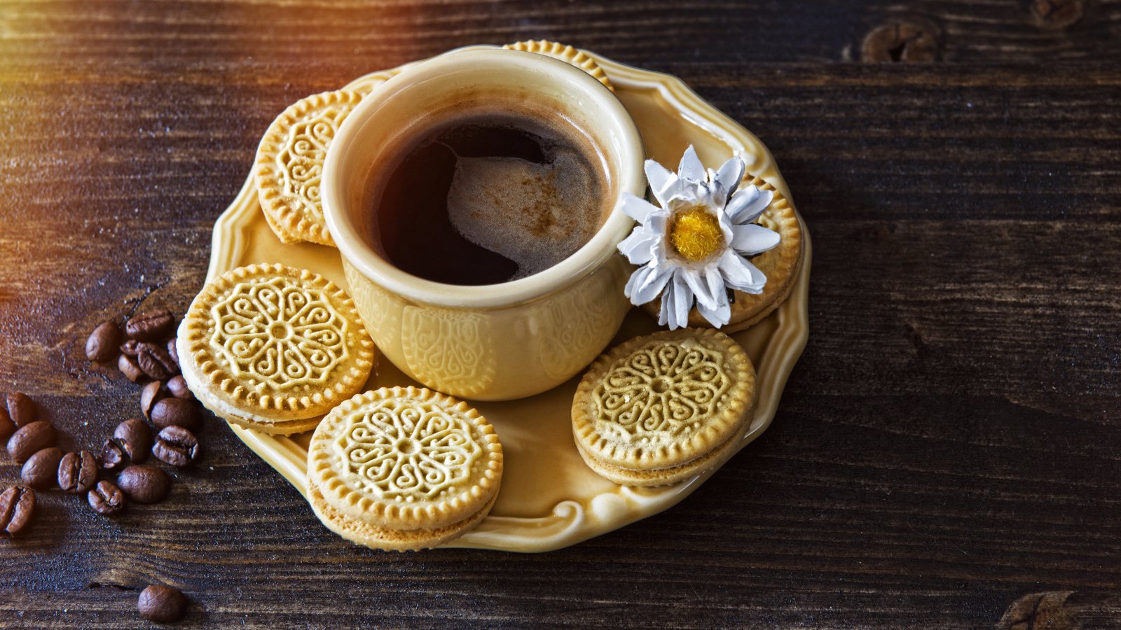 A cup of coffee on a saucer with biscuits