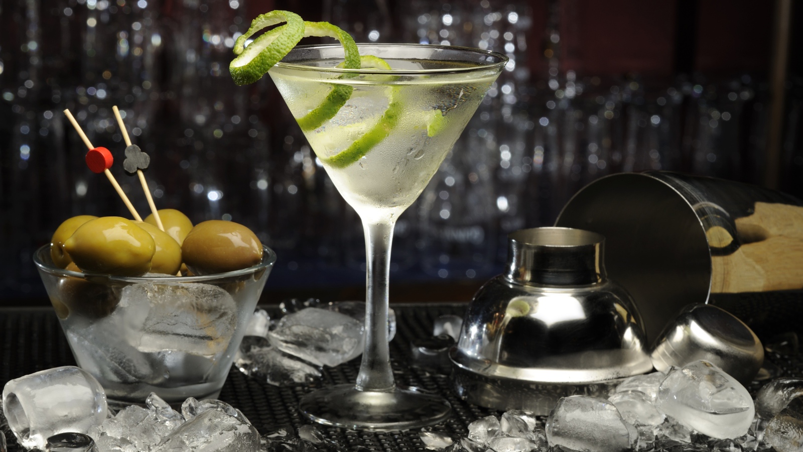 Коктейль с лаймом на столе с оливками и кубиками льда