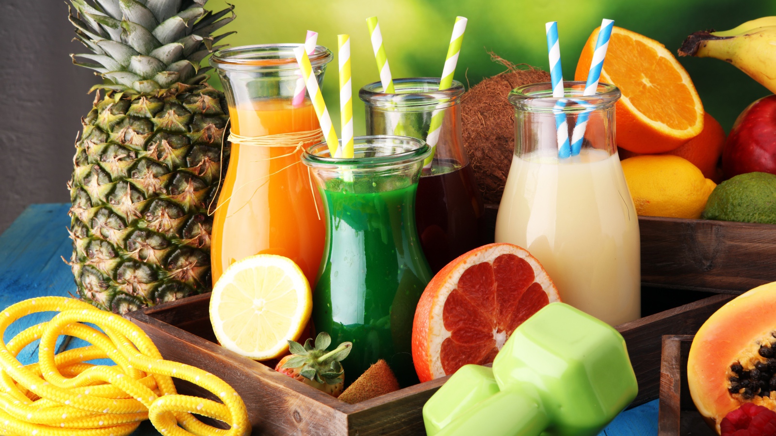 Коктейли в бутылках с трубочками на столе фруктами