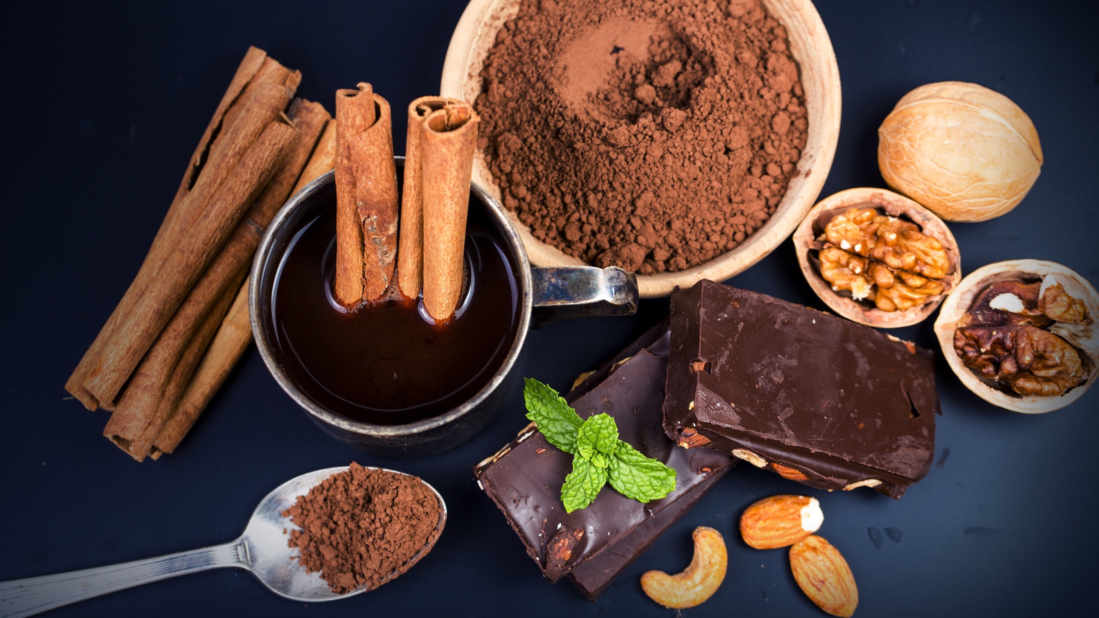 Какао с корицей, орехами и шоколадом на столе 