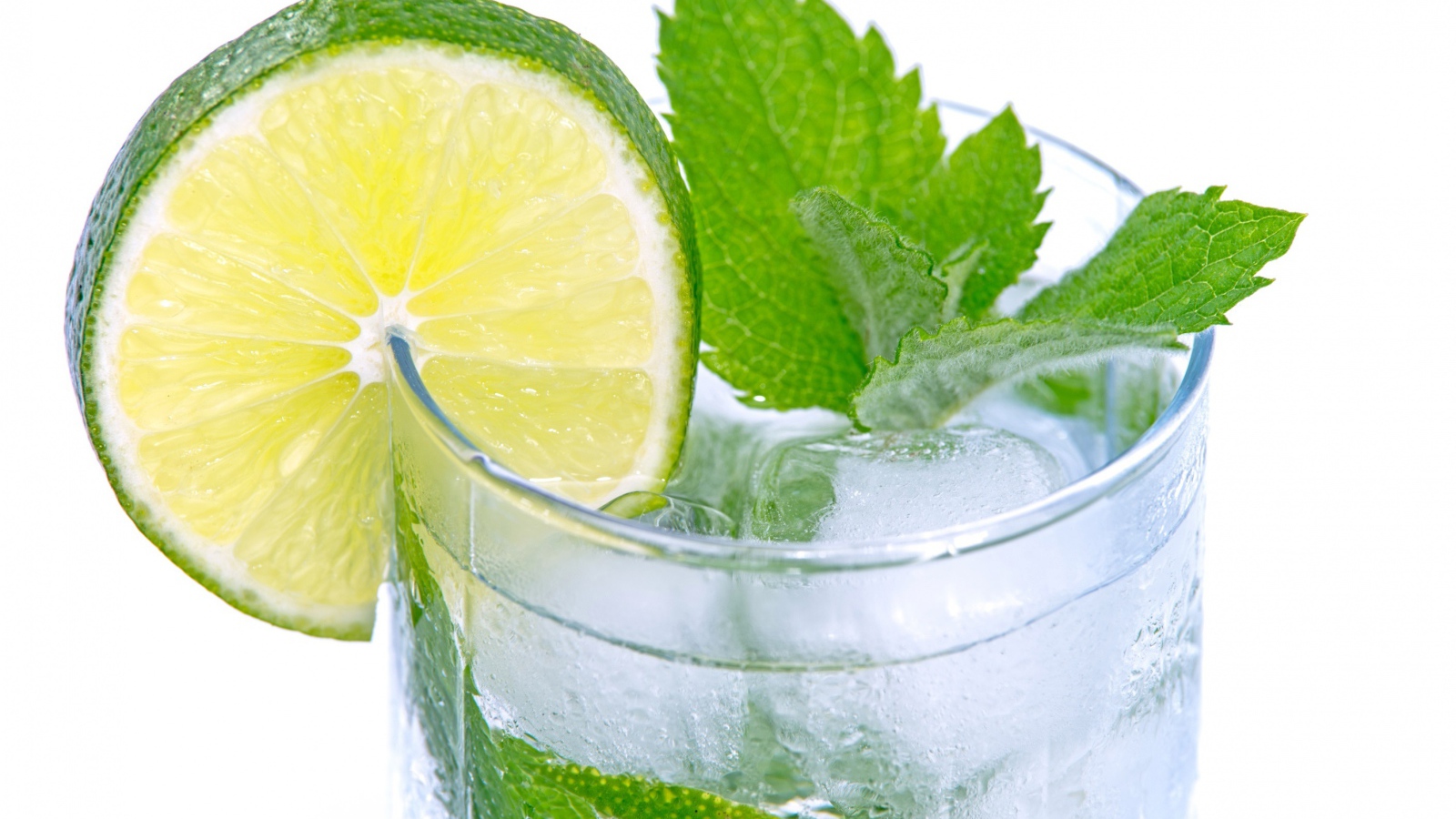 Стакан с освежающим напитком с мятой и лаймом на белом фоне