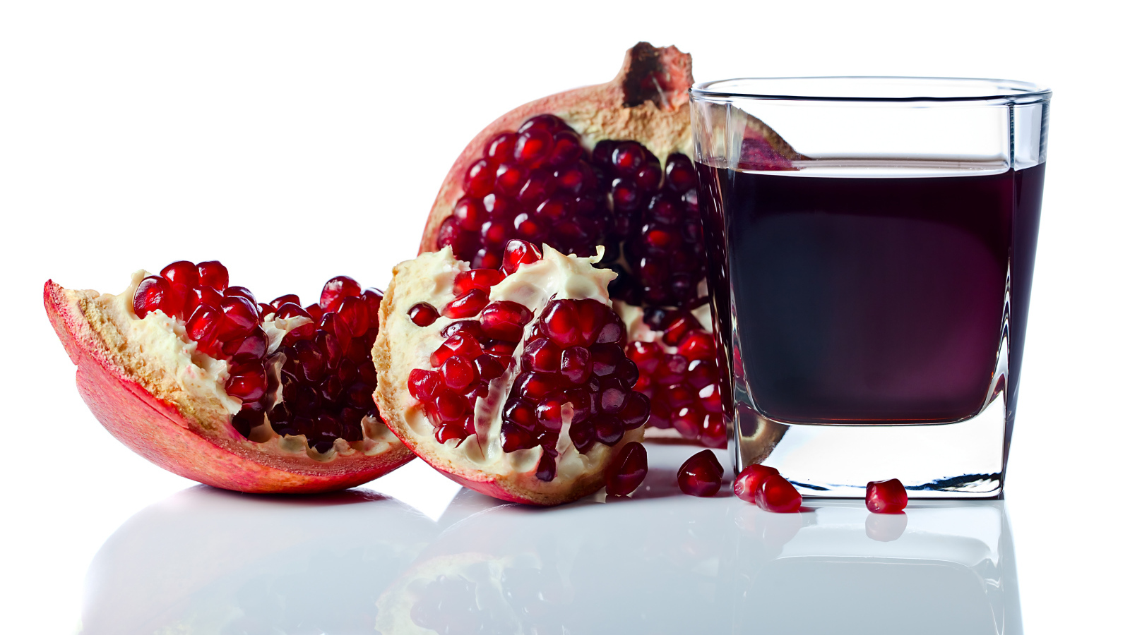Гранатовый сок с плодом граната на белом фоне