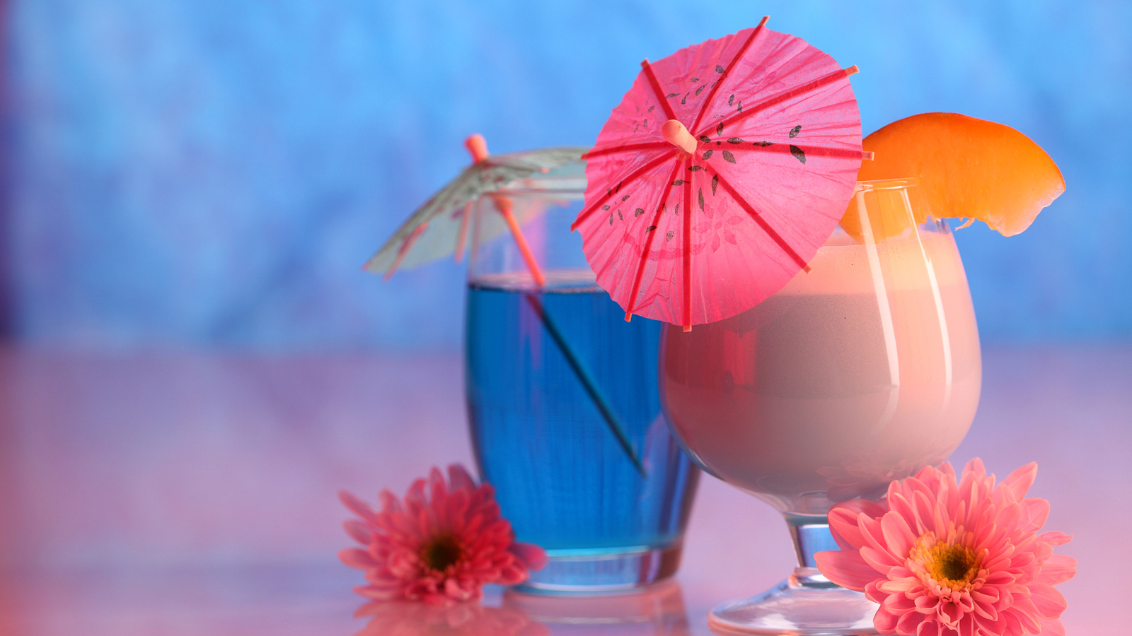 Два бокала с коктейлем на столе с розовыми цветами хризантемы