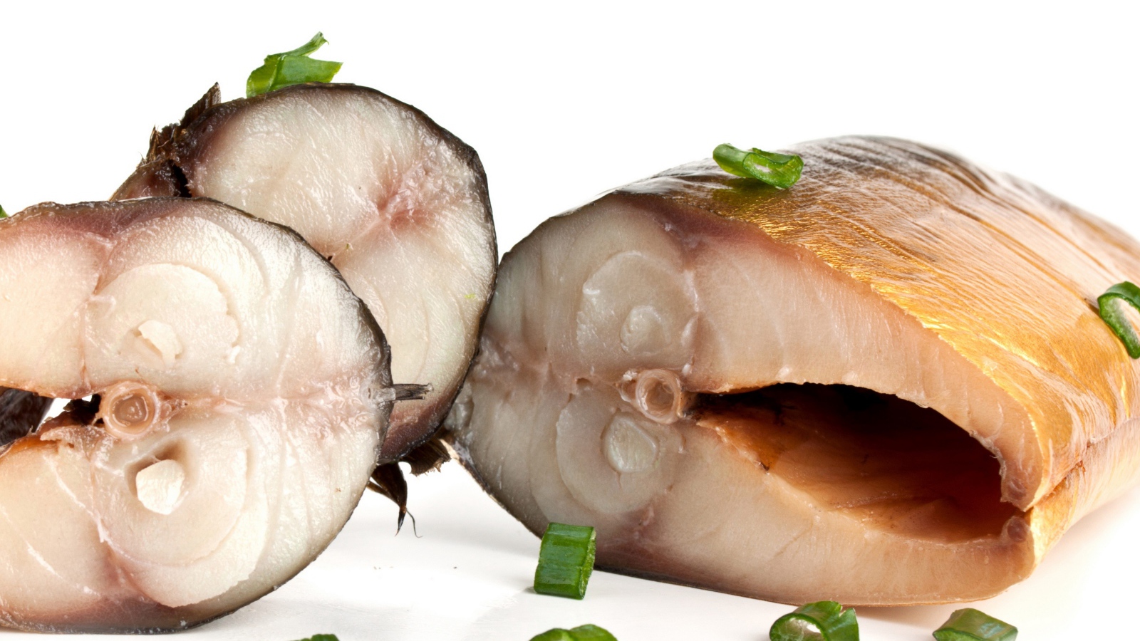 Аппетитная копченая скумбрия с зеленым луком на белом фоне