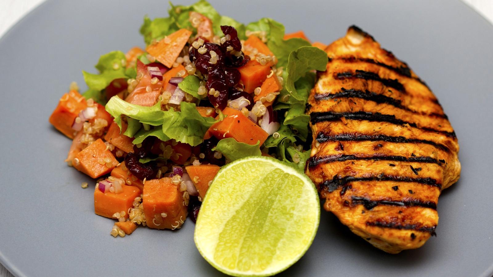 Мясо барбекю с овощами и лаймом на серой тарелке 