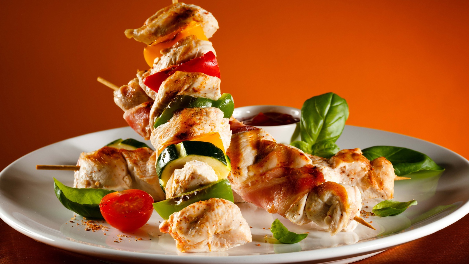 Куриные шашлыки с овощами на белой тарелке