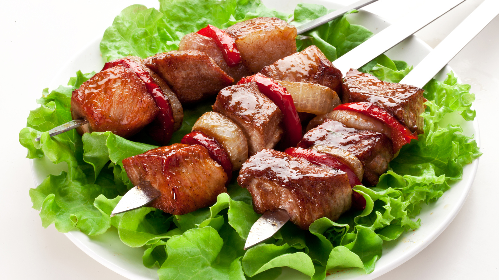 Аппетитный шашлык с листьями салата на шампурах 