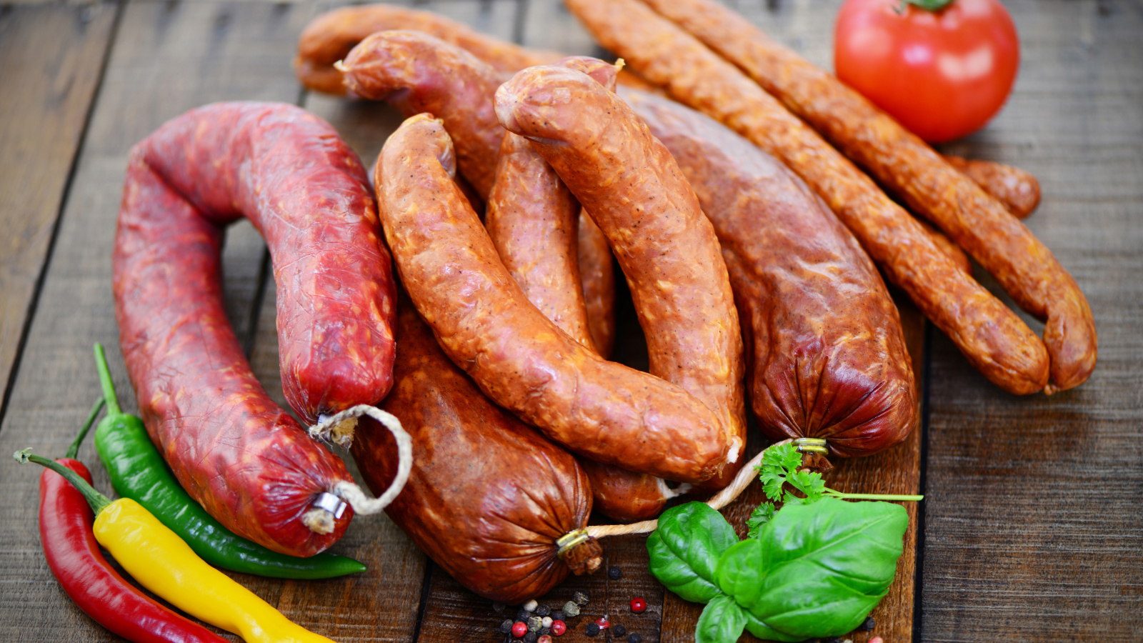 Свежие колбасы с перцем на столе