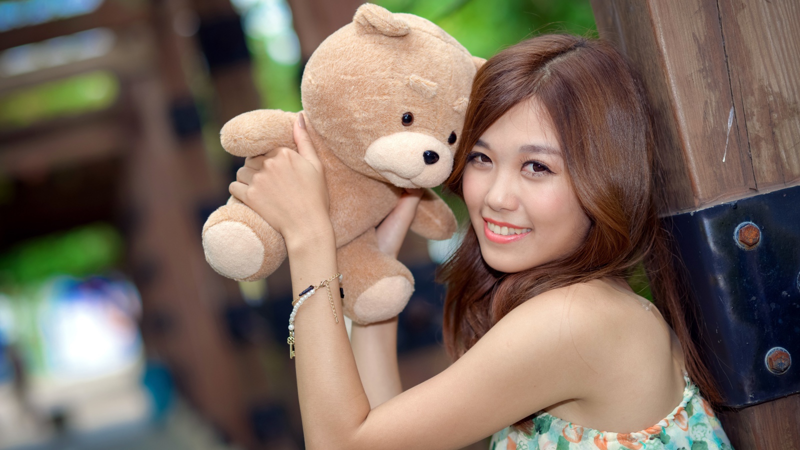 Красивая азиатка с плюшевым медведем в руках