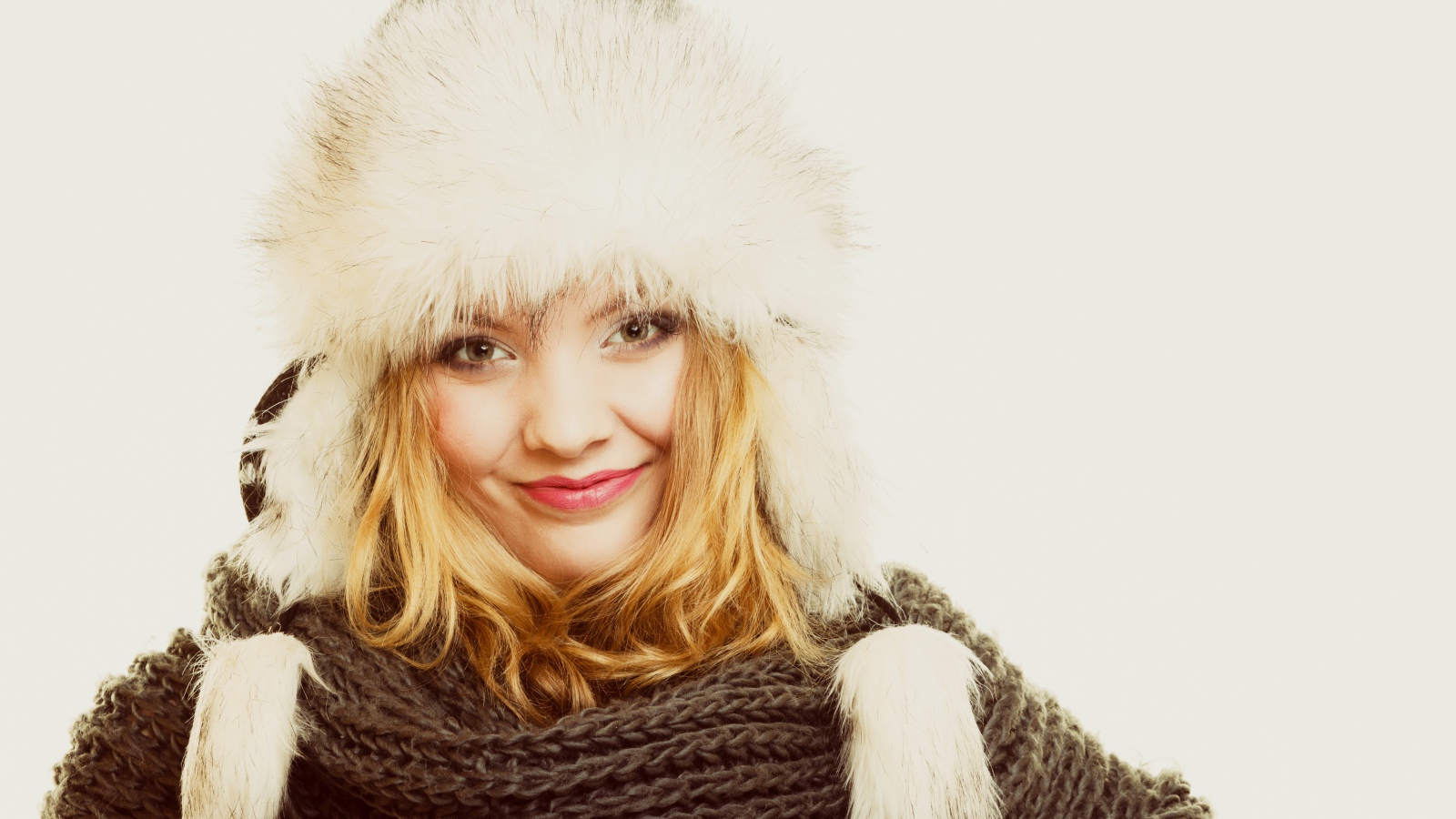 Красивая блондинка в теплой шапке с шарфом на шее