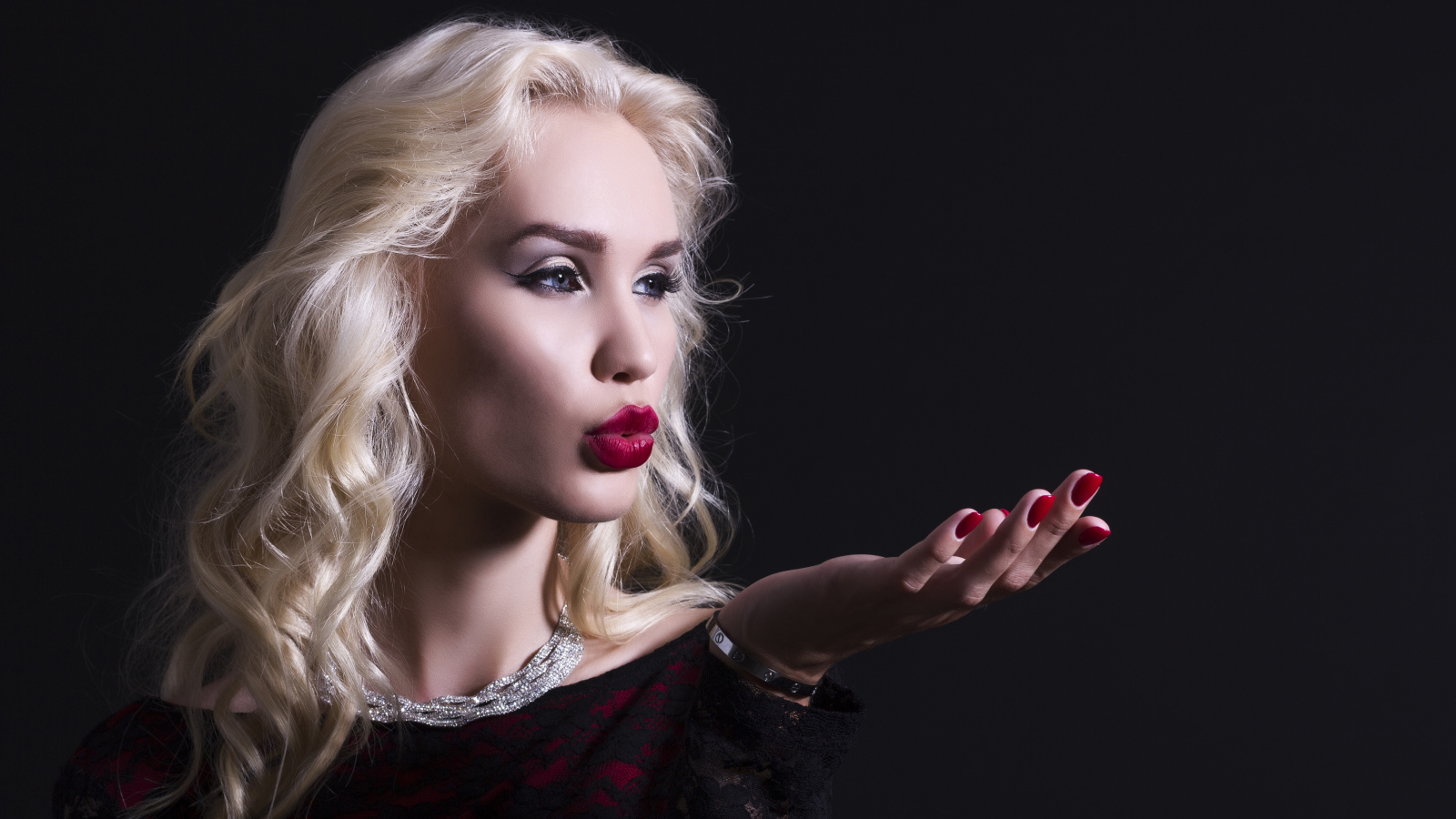 Красивая голубоглазая блондинка с красными губами в черном платье