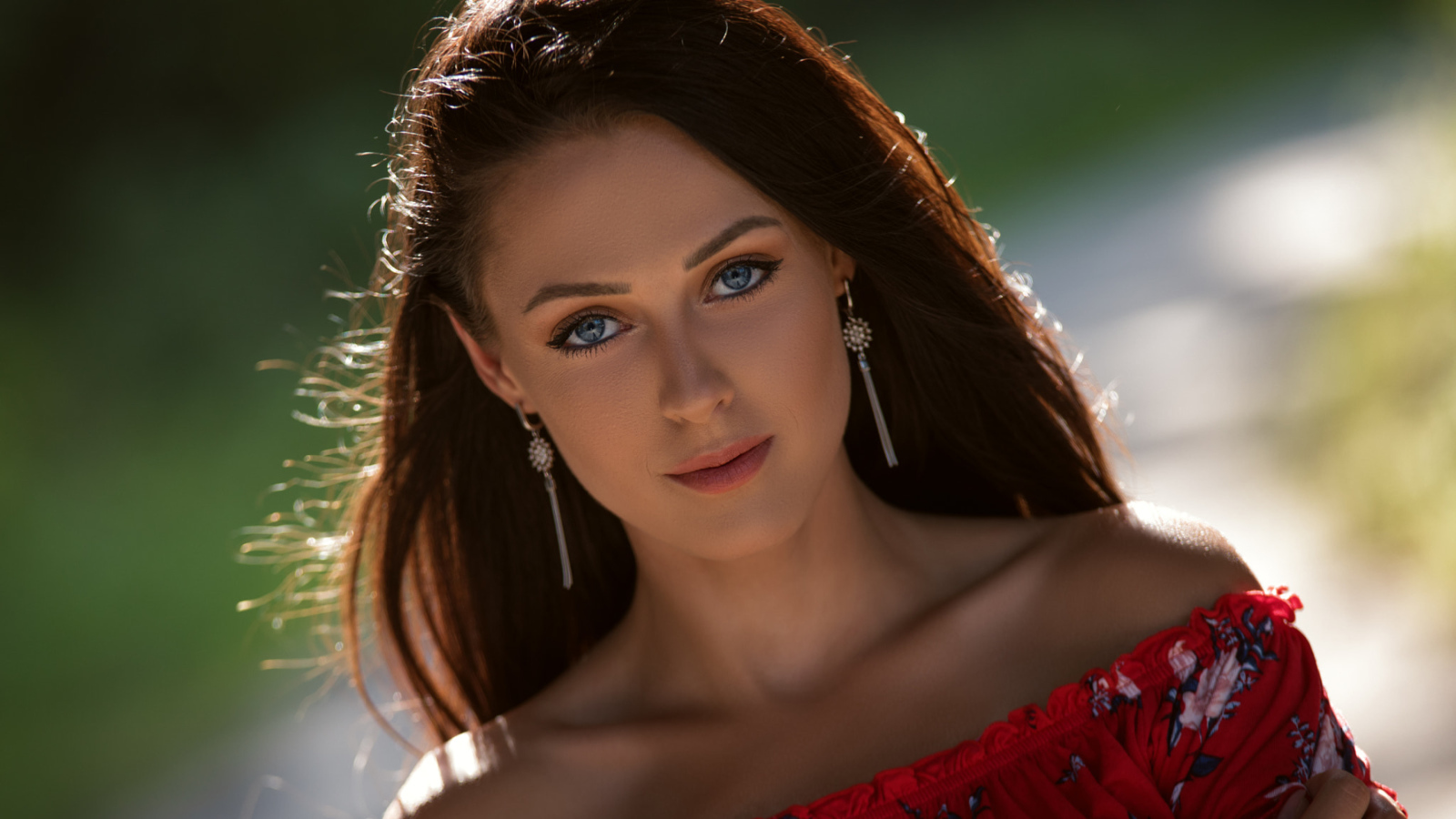 Красивая голубоглазая брюнетка с серьгами у ушах