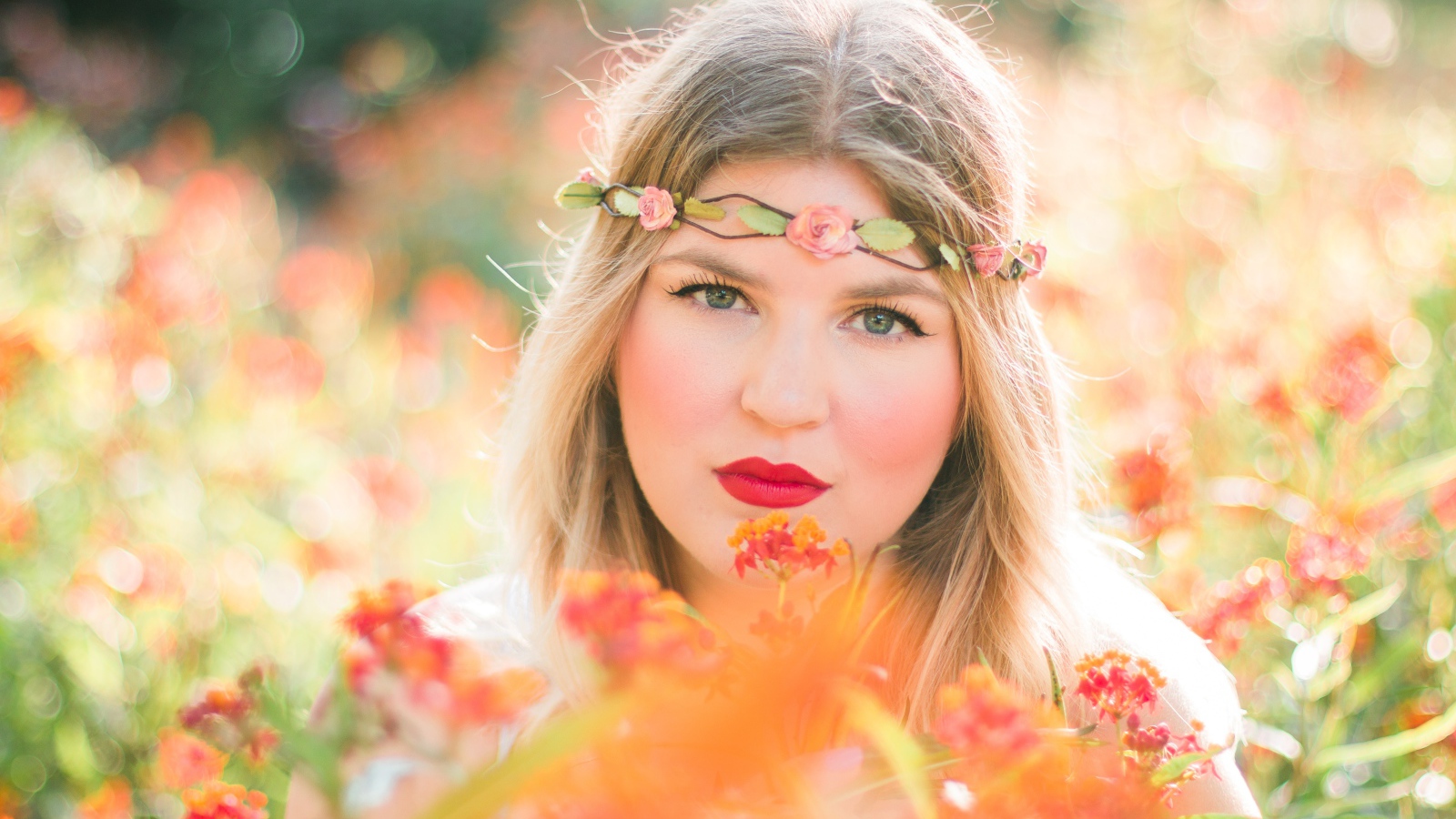 Красивая голубоглазая девушка в красных цветах