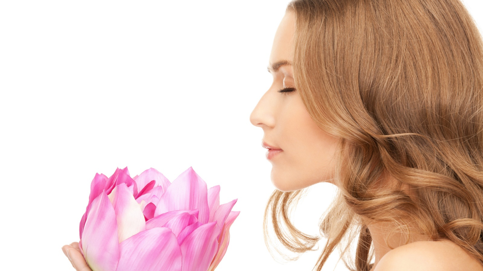 Красивая девушка шатенка наслаждается ароматом лотоса 