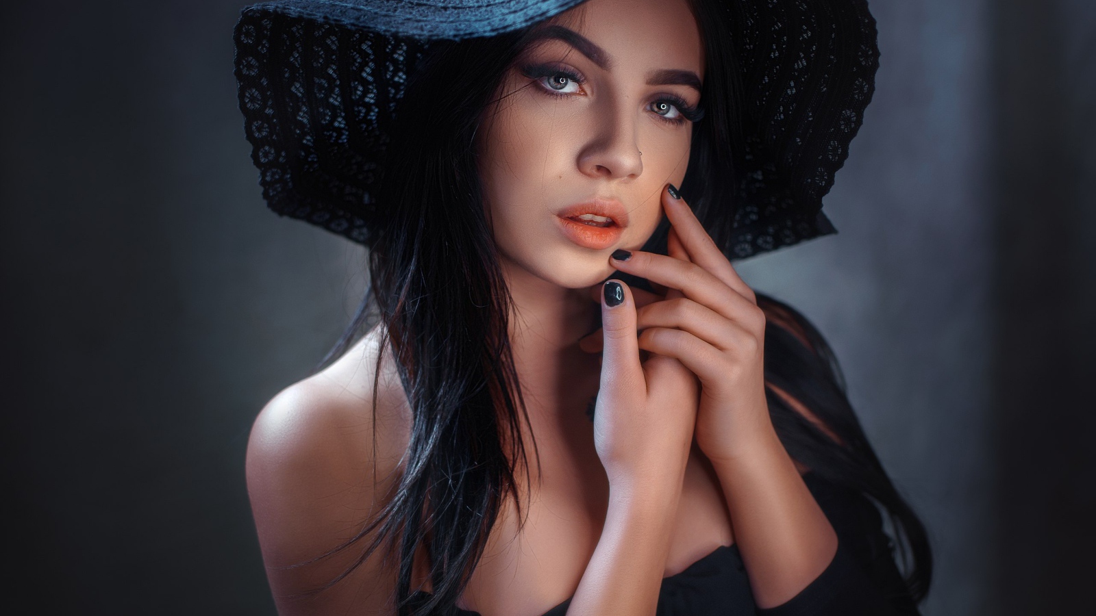 Красивая брюнетка в большой черной шляпе 