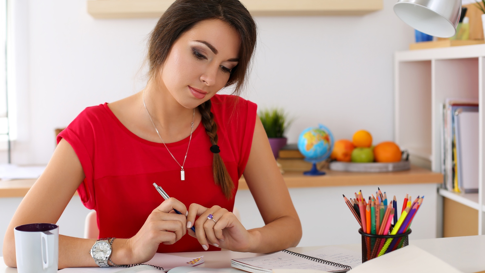 Красивая деловая девушка за столом с тетрадями