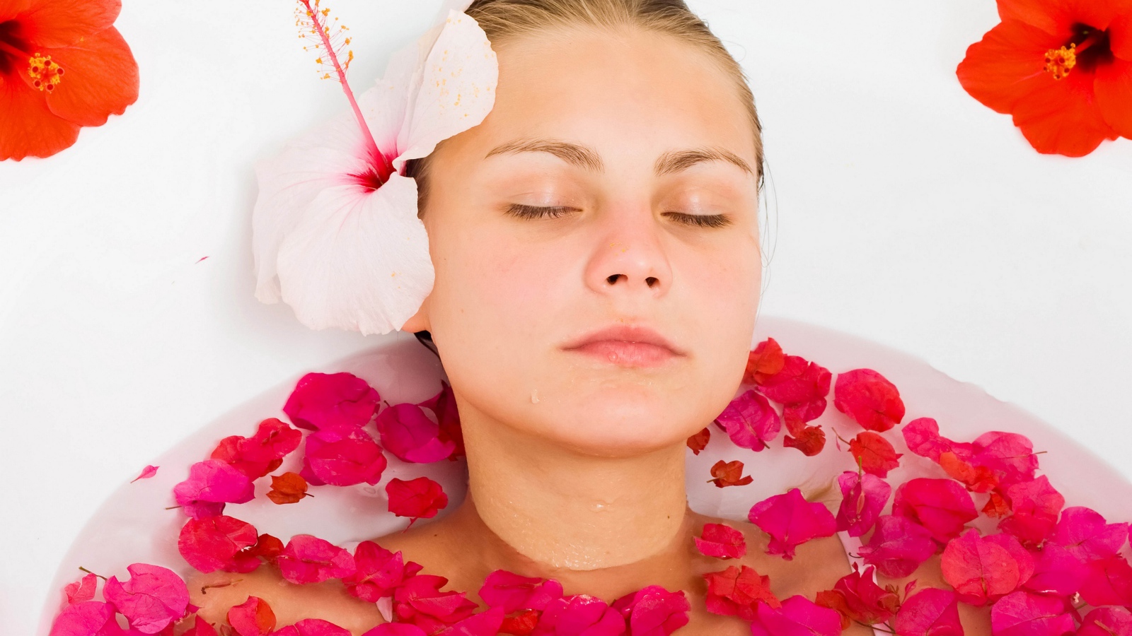Красивая девушка в ванной с лепестками розы 