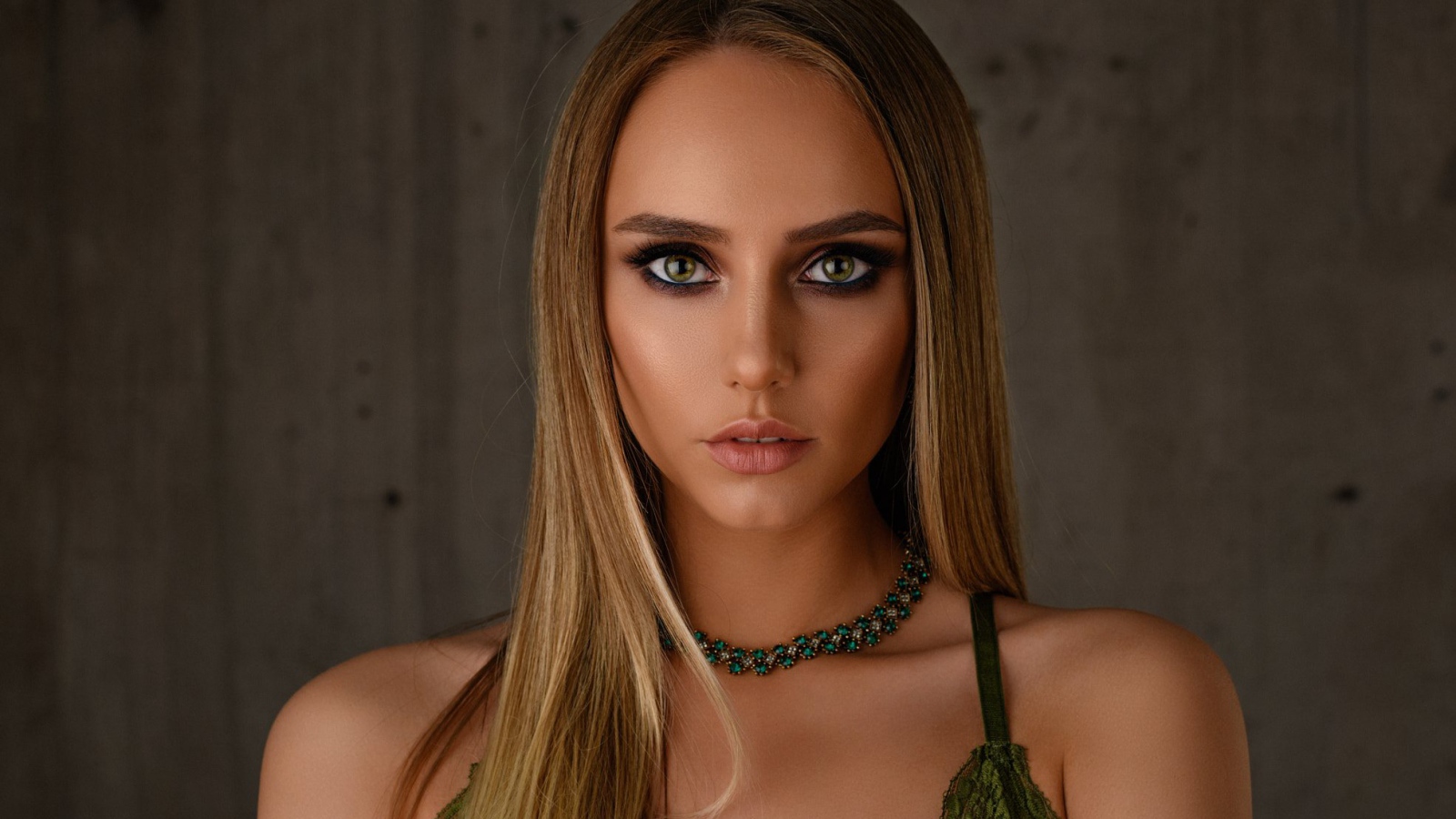 Красивая длинноволосая блондинка с украшением на шее 