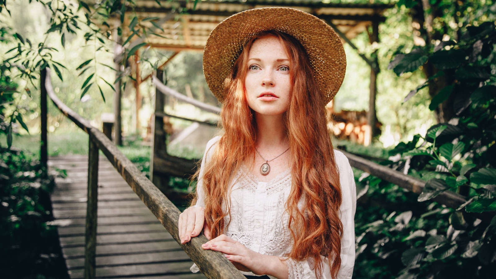 Красивая рыжеволосая девушка в соломенной шляпе