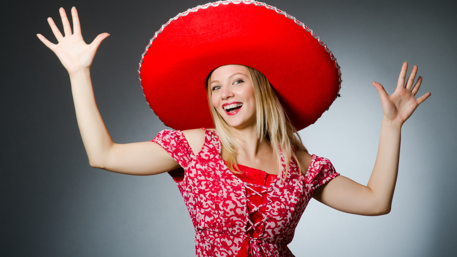 Красивая улыбающаяся блондинка в большой красной шляпе