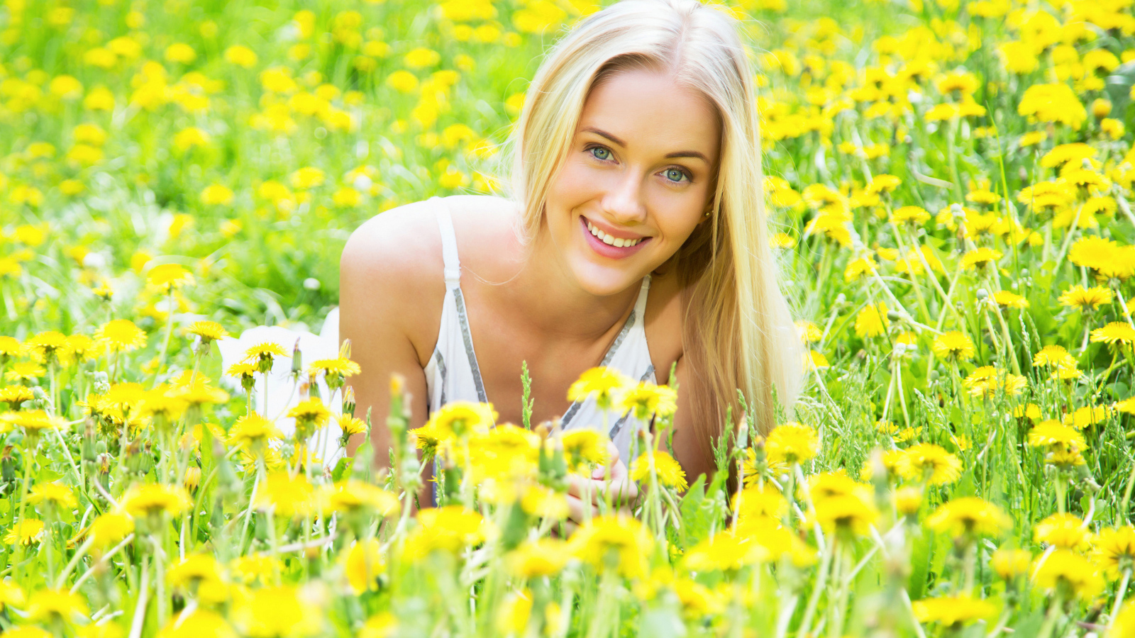Красивая улыбающаяся блондинка в желтых одуванчиках