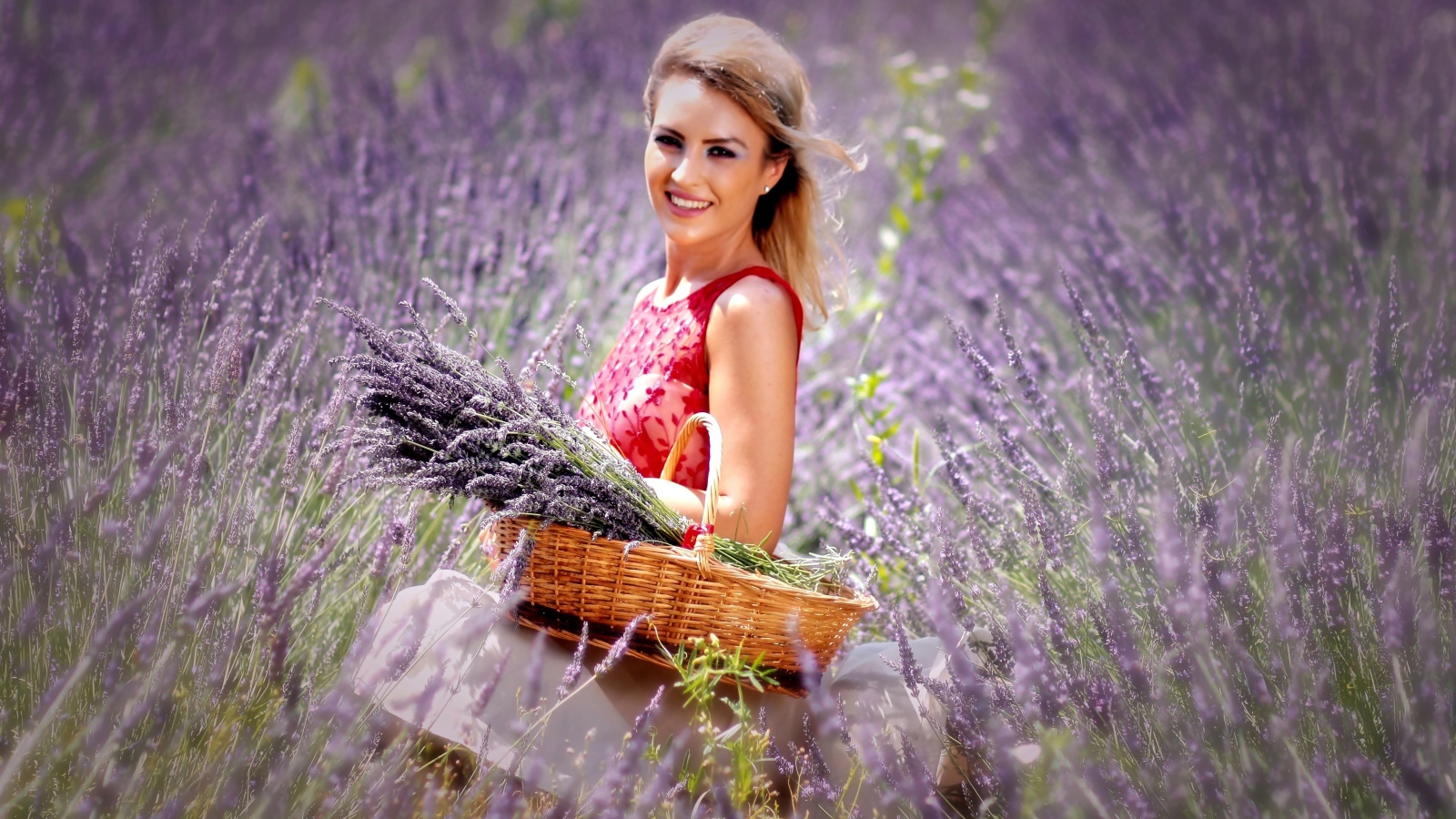 Красивая улыбающаяся девушка с корзиной на лавандовом поле