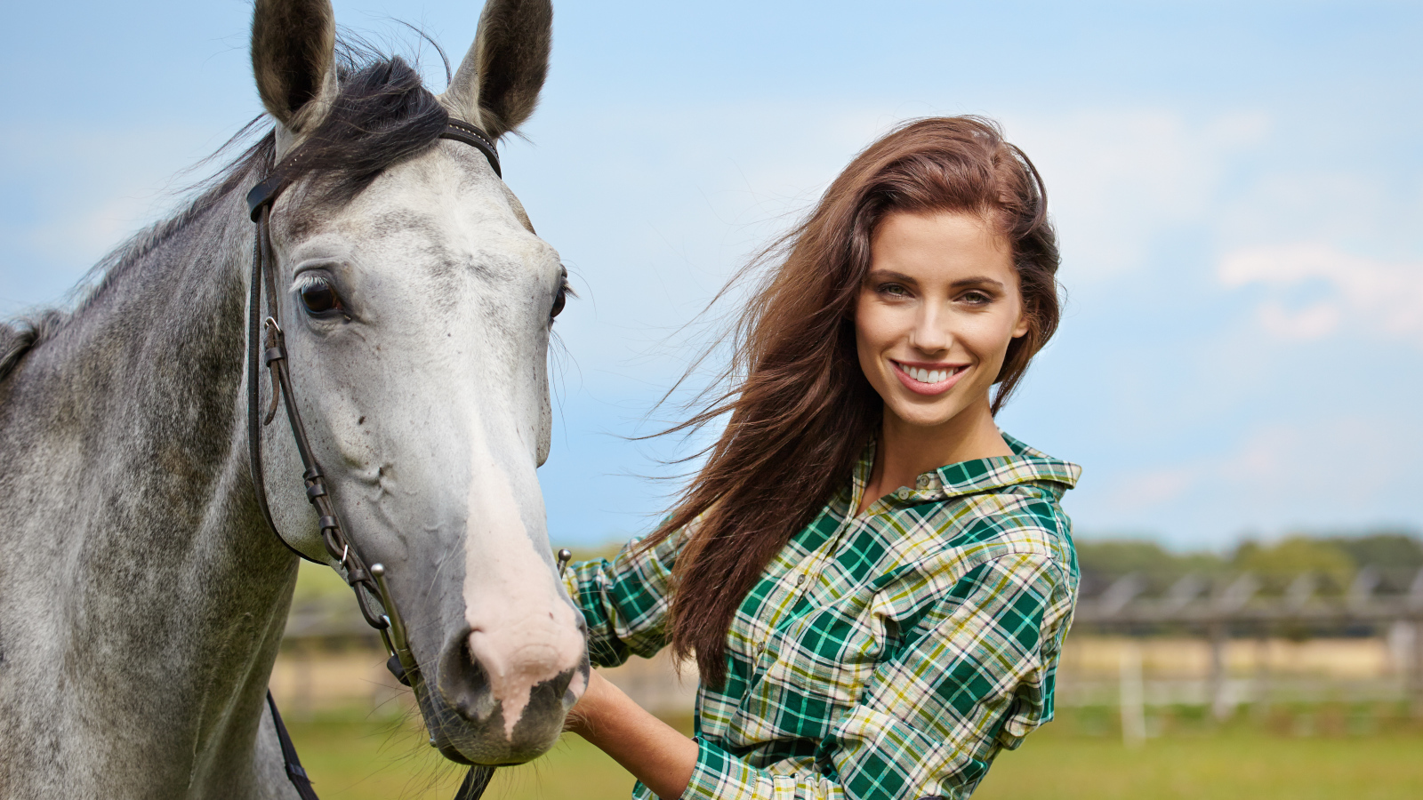 Красивая улыбающаяся девушка с конем