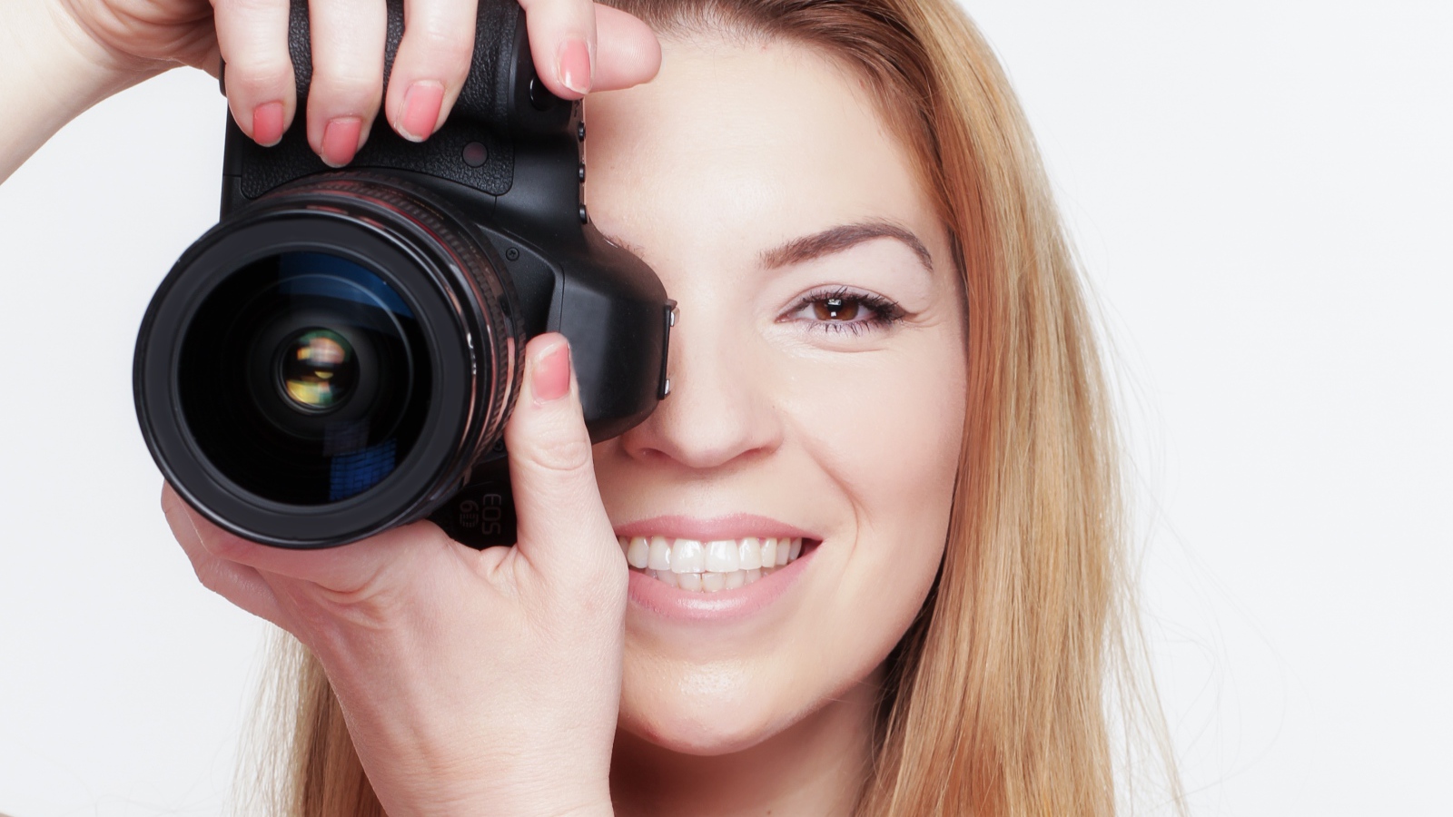 Красивая улыбающаяся девушка с фотоаппаратом