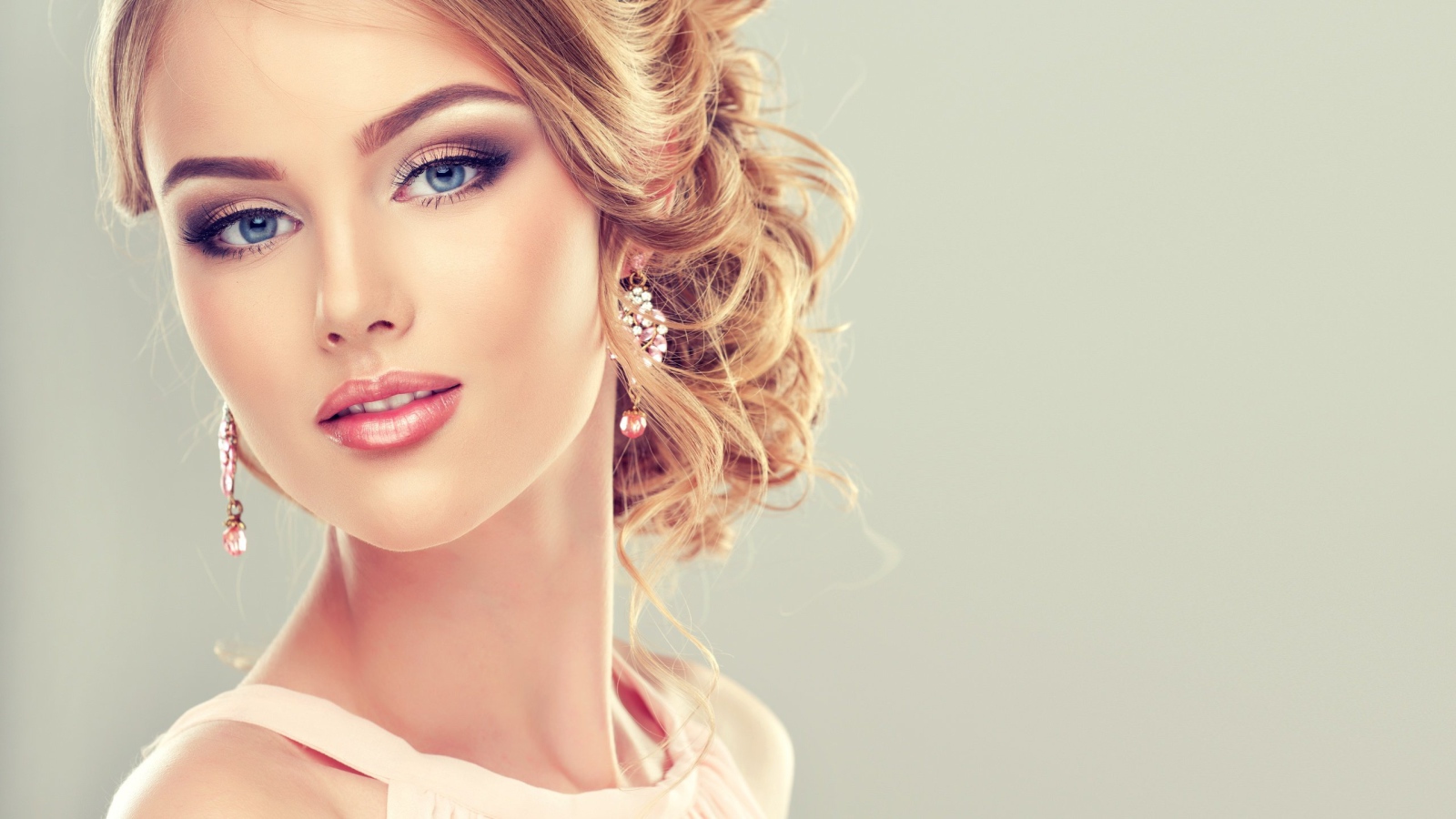 Красивая стильная голубоглазая девушка с красивым макияжем и прической