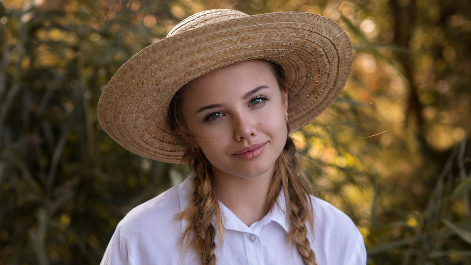 Красивая молодая девушка в соломенной шляпе