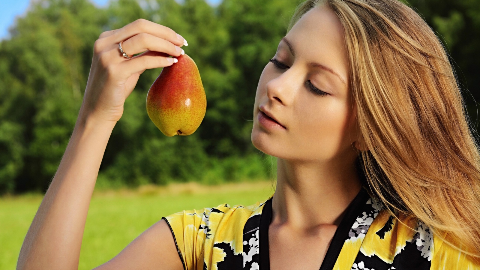 Красивая молодая девушка с грушей в руках