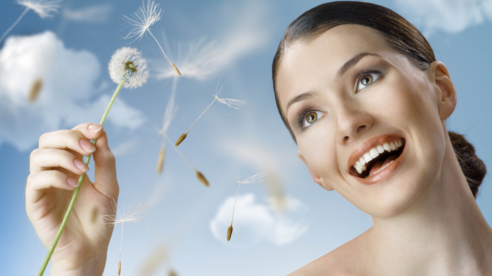 Счастливая девушка с одуванчиком в руке 