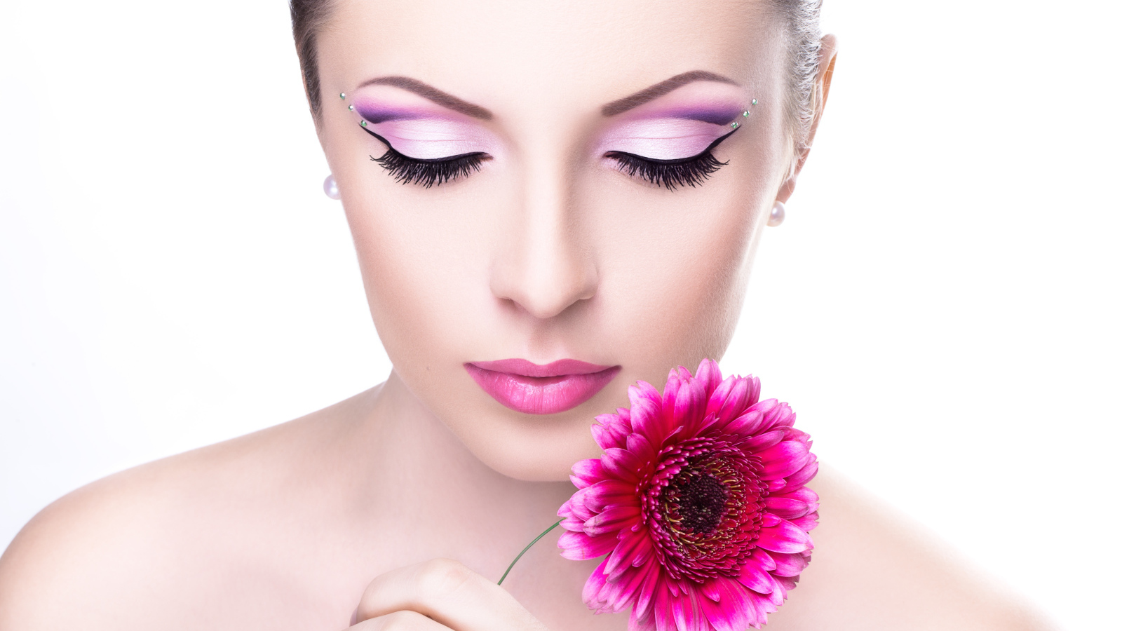 Девушка модель с нежным макияжем с розовым цветком герберы в руке