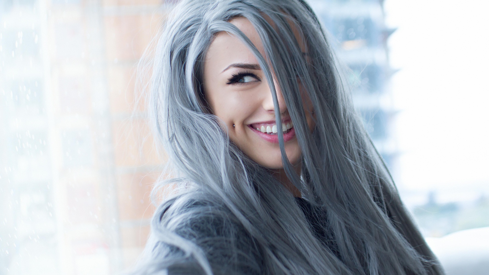 Улыбающаяся эпатажная девушка с пирсингом