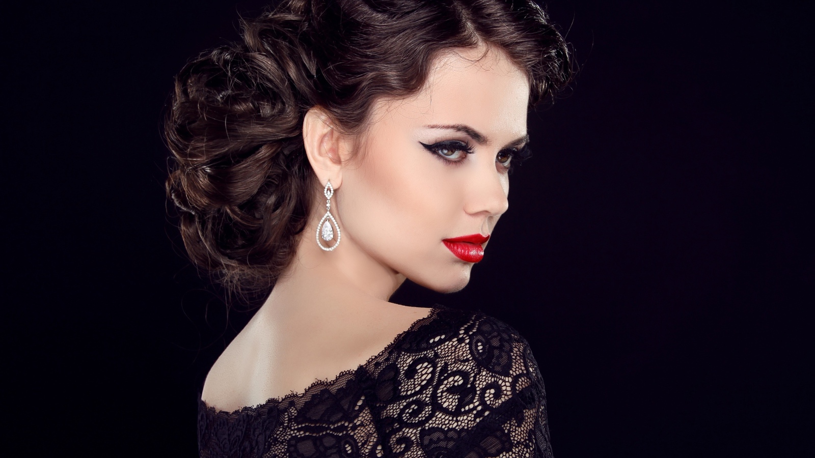 Эффектная брюнетка с ярким макияжем в черном платье